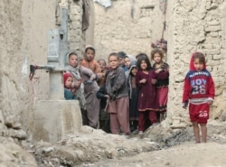 Internally displaced Afghan children are seen next to their shelters on the outskirts of Kabul, Feb. 3, 2021.