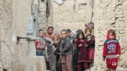 Internally displaced Afghan children are seen next to their shelters on the outskirts of Kabul, Feb. 3, 2021.