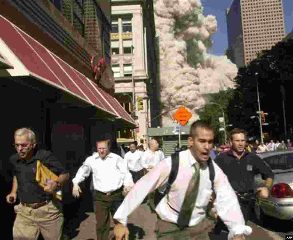 FILE - In this Tuesday, Sept. 11, 2001 file photo, people run from a cloud of debris from the collapse of a World Trade Center tower in New York. (AP Photo/Suzanne Plunkett)