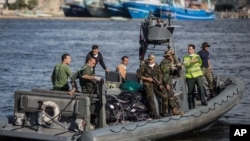 FILE - An Egyptian coast guard dinghy brings bodies from a Europe-bound boat that capsized off Egypt’s Mediterranean coast, to the shore in Rosetta, Egypt, Sept. 22, 2016.