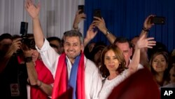 Presiden Terpilih Paraguay Mario Abdo Benitez, kiri, dari Partai Colorado dan istrinya, Silvana Lopez Moreira, melambaikan tangan ke para pendukungnya dalam perayaan kemenangan di markas partai di Asuncion, Paraguay, Minggu, 22 April 2018. 