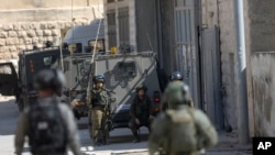 Les forces de sécurité israéliennes font un raid sur le village de Deir Abu Mash'al près de Ramallah, le 17 juin 2017.
