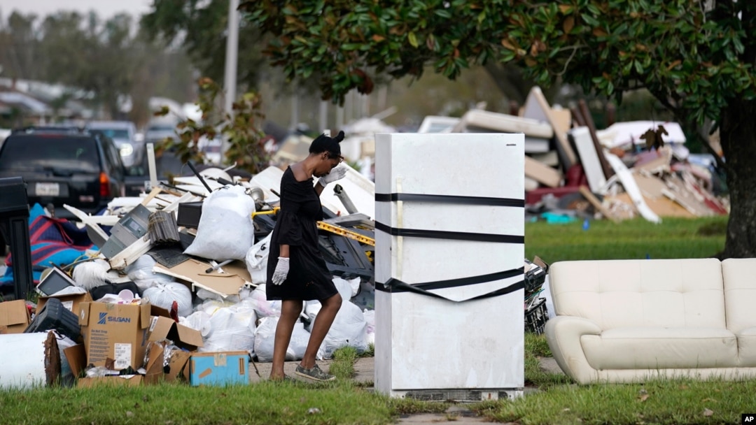 Seorang warga bernama Lori Butler tampak menyeka keningnya saat ia berusaha memindahkan puing puing dari rumahnya yang terendam banjir akibat diterjang badai Ida di LaPlace, Louisiana, AS, pada 7 September 2021. (Foto: AP)