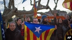 Pro-independence supporters holds "estelada" flags as they celebrate the results of a symbolic declaration of sovereignty in front of Catalonia's Parliament in Barcelona, Spain, Jan. 23, 2013. 