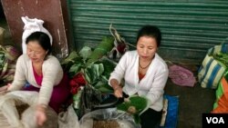 A stall owner in a market in Gangtok city in India's northeast wraps fermented soya beans in a leaf, one of the alternates used in place of plastic for packaging. (A. Pasricha/VOA)