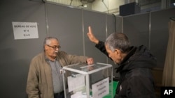 A Algerian voter casts his vote, Thursday, Dec.12, 2019, at the Algerian consulate in Marseille, southern France.