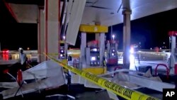 In this image made from video, debris from tornadoes pile around the pumps of a gas station, Oct. 10, 2021, in Shawnee, Oklahoma.