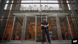 New York Times ရဲ့ အဆောက်အဦးအရှေ့အပြင်ဘက်တွက် အစောင့်တာဝန်ယူနေသော ရဲ တဦး (သတင်းဓာတ်ပုံ - ဇွန် ၂၈၊ ၂၀၁၈)