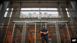 FILE - A police officer stands guard outside The New York Times building in New York, June 28, 2018.