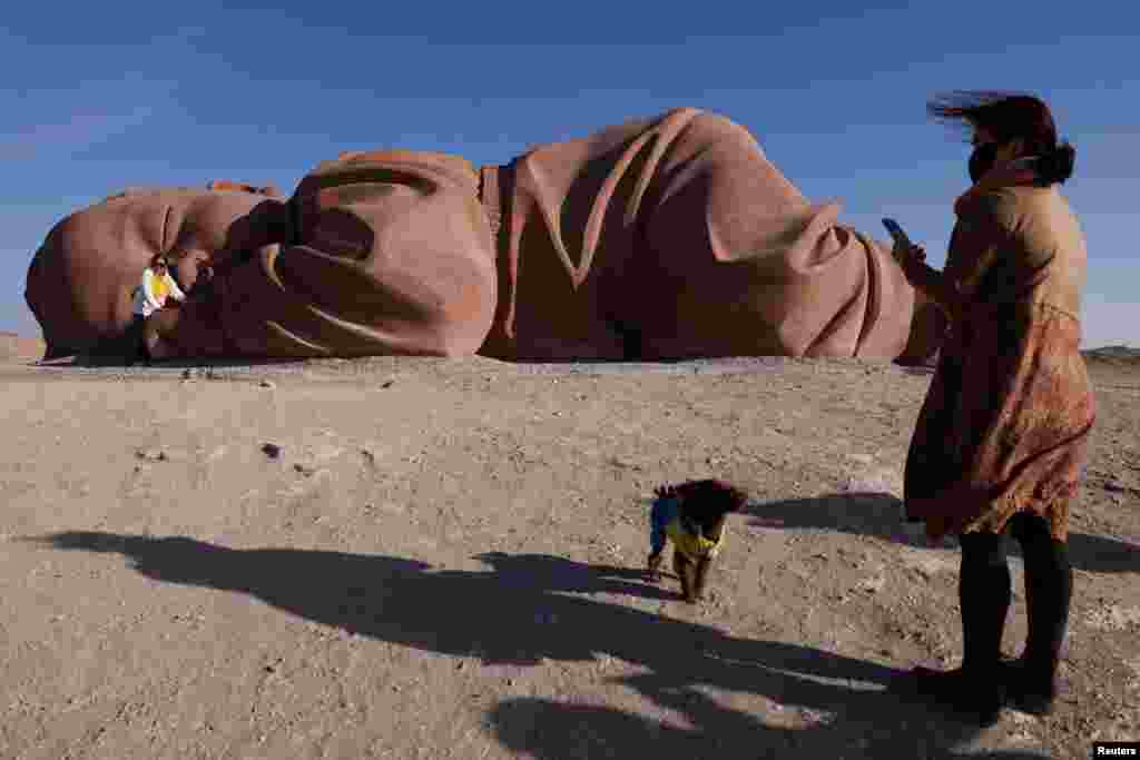 Tourists visit a sculpture in Gobi desert in Guazhou, during an organized media tour in Gansu province, China.