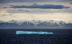 FILE - An iceberg floats past Bylot Island in the Canadian Arctic Archipelago, July 24, 2017.