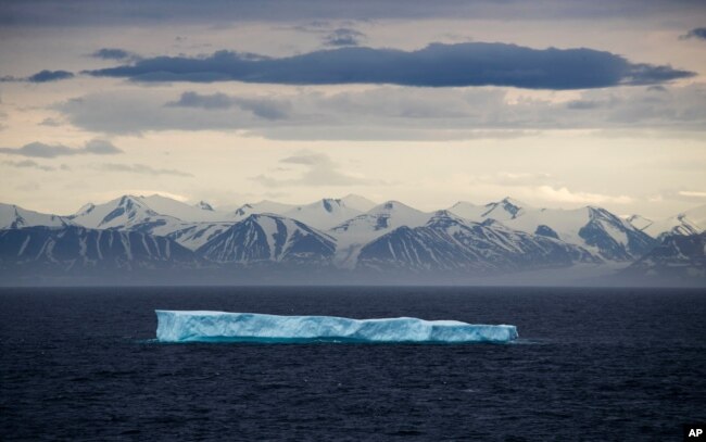 FILE - An iceberg floats past Bylot Island in the Canadian Arctic Archipelago, July 24, 2017.