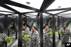 Paradox Museum Miami guide Maria Wong walks through a mirror maze as she checks for areas that need cleaning, Tuesday, Jan. 28, 2025, in Miami. (AP Photo/Rebecca Blackwell)