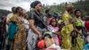 Congolese families displaced by ongoing clashes in eastern Democratic Republic of Congo line up as they wait for Rwandan police and immigration officials to allow them to return to the country, following the takeover of the Congolese city of Bukavu by M23