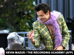 FILE - In this photo, singer Harry Styles rubs elbows with singer Billie Eilish at the 63rd Annual Grammy Awards at Los Angeles Convention Center on March 14, 2021 in Los Angeles, California. (Photo by Kevin Winter / The Recording Academy / AFP)