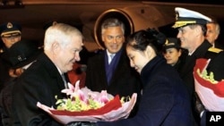 U.S. Secretary of Defense Robert Gates (L) receives flowers as he arrives at Beijing International Airport to start his four-day visit to China, 09 Jan 2011