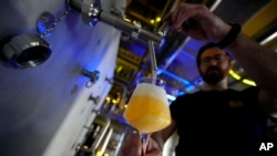 Head Brewmaster Tobias Zollo fills beer at the Weihenstephan brewery in Freising, Germany, Sept. 20, 2024.