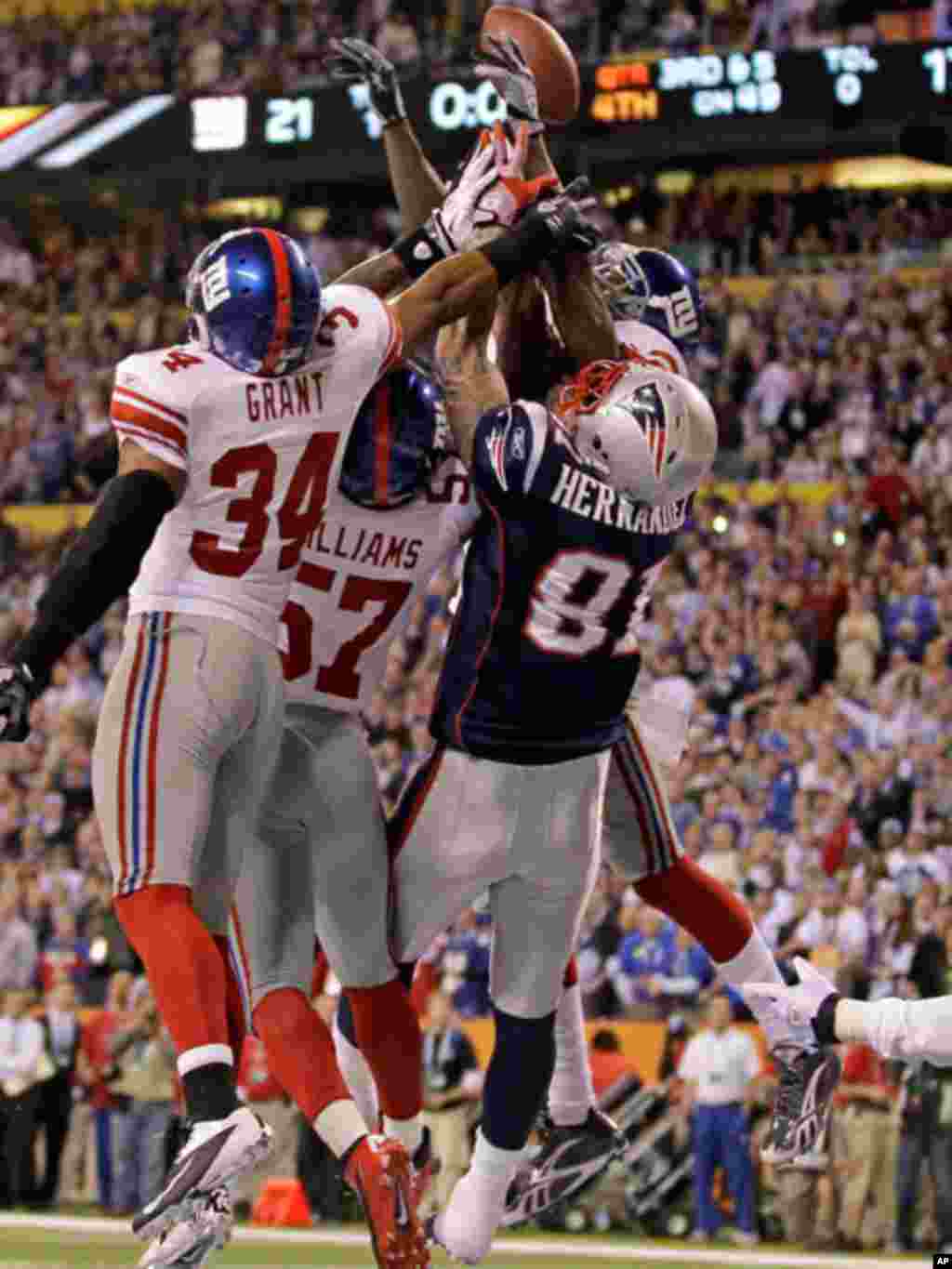 New York Giants safety Deon Grant (34), linebacker Jacquian Williams (57) and safety Kenny Phillips (21) block the final pass to New England Patriots tight end Aaron Hernandez (81) in the NFL Super Bowl XLVI football game, Sunday, Feb. 5, 2012, in Indiana