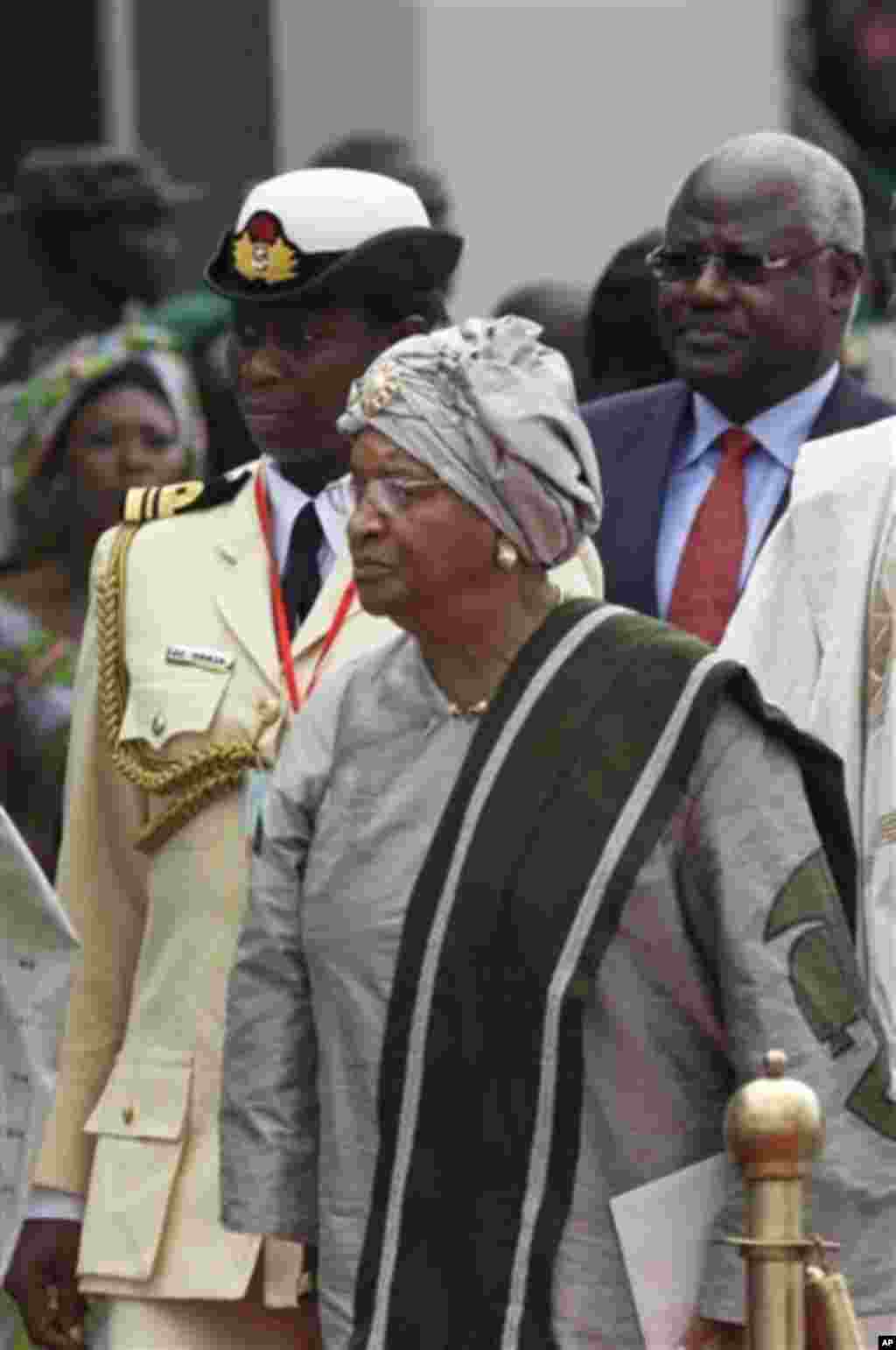 Liberian President Ellen Johnson-Sirleaf, center, arrives for the inauguration ceremony of Nigeria President Goodluck Jonathan at the main parade ground in Nigeria's capital of Abuja, Sunday, May 29, 2011. Jonathan was sworn in Sunday for a full four-year