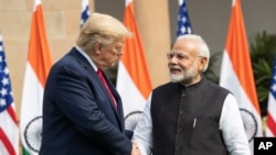 ARCHIVO - El expresidente estadounidense Donald Trump, a la izquierda, y el primer ministro indio, Narendra Modi, se dan la mano antes de reunirse en Nueva Delhi, India, el 25 de febrero de 2020.