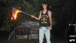 FILE - This undated photo taken from Lastrhodesian.com on June 20, 2015, allegedly shows Dylann Roof burning a U.S. flag. The site is no longer in operation. 