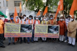 FILE - Supporters of Vishwa Hindu Parishad, or World Hindu Council, hold posters showing coffins of Indian army soldiers killed in clashes with China, during a protest in Ahmedabad, India, June 20, 2020.