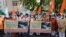 Supporters of Vishwa Hindu Parishad, or World Hindu Council, hold posters showing coffins of Indian army soldiers killed in clashes with China, during a protest in Ahmedabad, India, June 20, 2020. 