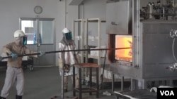 Cambodian workers at Nikko-Kinzokou's factory at the Phnom Penh Special Economic Zone feed molds into a furnace. The factory produces heat-resistant stainless steel baskets to hold and transport auto-parts. (D. de Carteret/VOA)