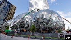 FILE - In this April 27, 2017 file photo, construction continues on three large, glass-covered domes as part of an expansion of the Amazon.com campus in downtown Seattle. Amazon is looking for the location of its second home base.