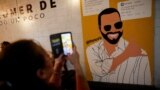 ARCHIVO - Una mujer toma fotografías de un mural que representa al presidente de El Salvador, Nayib Bukele, quien se postula para la reelección, dentro de un restaurante antes de las elecciones presidenciales y del Congreso, en Mejicanos, El Salvador, el 29 de enero de 2024.