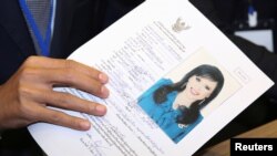 Thai Raksa Chart party leader Preechapol Pongpanich, holds up application of candidate for Prime Minister, Thailand's Princess Ubolratana Rajakanya Sirivadhana Barnavadi, at the election commission office in Bangkok, Thailand, Feb. 8, 2019. 