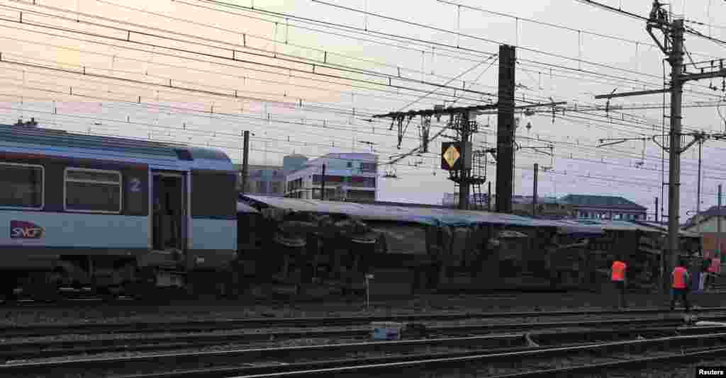 Empleados del servicio ferroviario de Francia junto a los restos del tren descarrilado cerca de la estación de Bretigny-sur-Orge, el pasado 12 de julio.