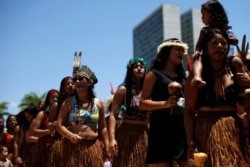 FILE - Indigenous people from ethnic groups Pataxo and Tupinamba attend a protest to defend indigenous land, outside Brazil's Supreme Federal Court in Brasilia, Brazil, Oct. 16, 2019.