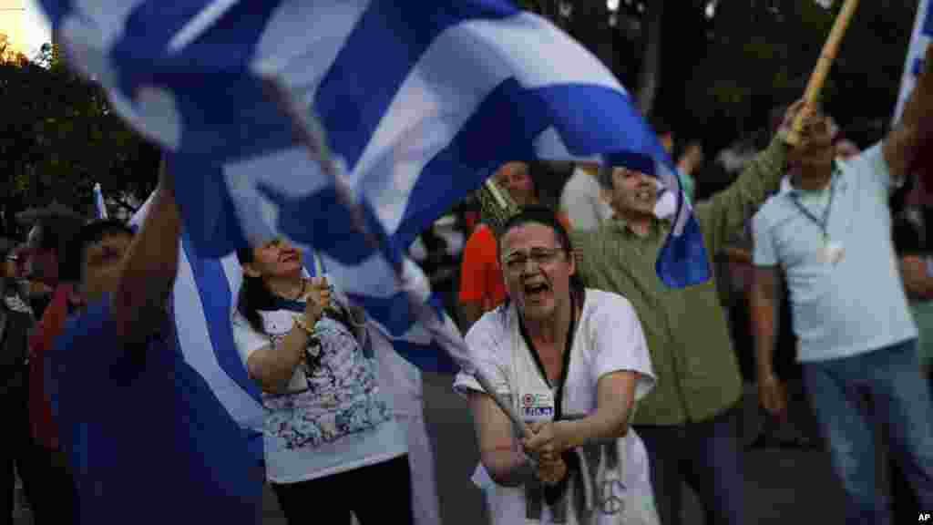 Un partisan du Non au référendum en Grèce, hissant le drapeau sur la place Syntagma