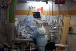 Medical professionals in full protective equipment tend to an elderly man on a ventilator in the critical care coronavirus unit at Sheba Medical center in Ramat Gan, Israel, Sept. 30, 2020.