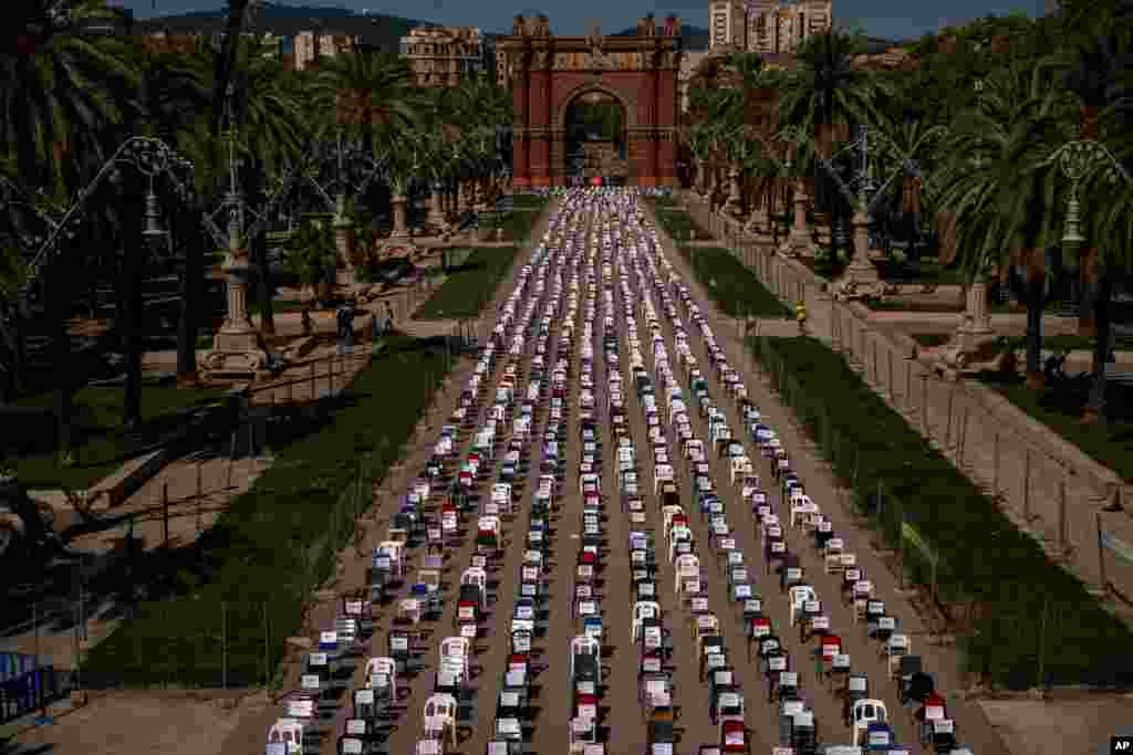Empty chairs with the names of activists are seen placed on a boulevard with the triumphal arch at the background, during a symbolic event marking Catalan National Day in Barcelona, Spain.