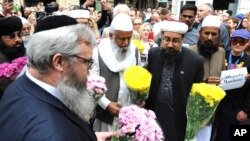 Members of the British Muslim Forum and religious leaders from Christian and Jewish faiths pay their respects at St Ann's square in Manchester, England Sunday May 28, 2017.