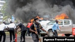 উগান্ডার কাম্পালায় সংসদ ভবনের কাছে গাড়িতে বোমা বিস্ফোরণের ফলে সৃষ্ট আগুন নেভানো হচ্ছে। ১৬ই নভেম্বর, ২০২১, ছবি-এএফপি