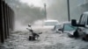 Autos y una moto bajo el agua al paso del huracán Sally por Pensacola, Florida, el 16 de septiembre de 2020.