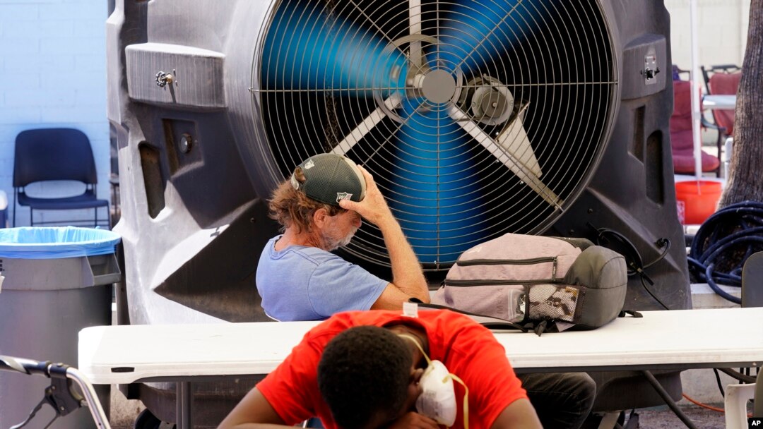 Dua pria tunawisma mendinginkan diri di Justa Center, layanan khusus bagi warga tunawisma, saat suhu mencapai 110 derajat (di atas 43 Celsius) di Phoenix, Arizona (foto: dok).