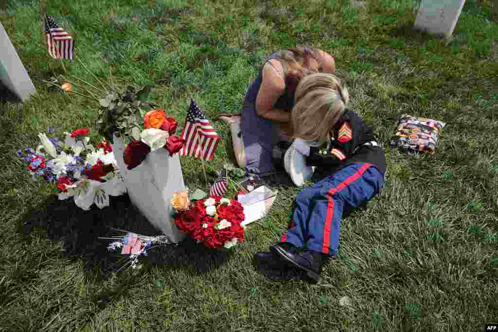 Brittany Jacobs of Hertford, North Carolina, embraces her son, Christian Jacobs, 6, next to the grave of her husband, U.S. Marine Corps Sgt. Chris Jacobs, in Section 60 at Arlington National Cemetery on Memorial Day in Arlington, Virginia.