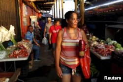 Cuban migrant Yunia Alvarez, a nurse who ran out of money, works selling coffee on the street in Paso Canoas, Panama, on the border with Costa Rica, March 22, 2016. Alvarez has the funds her family needs to reach the U.S.; money she makes selling coffee is for everyday expenses.