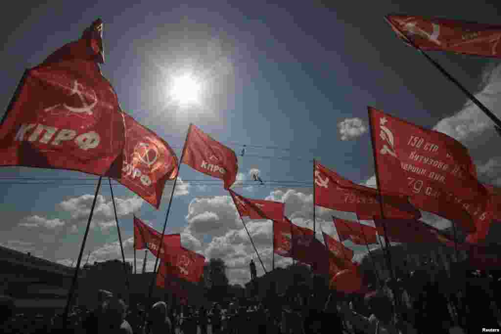 Supporters of the Communist Party hold flags during a May Day rally in Simferopol, Crimea, May 1, 2016. 