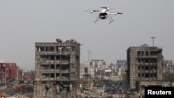 A drone operated by paramilitary police flies over the site of last week's explosions at Binhai new district in Tianjin, China, August 17, 2015.