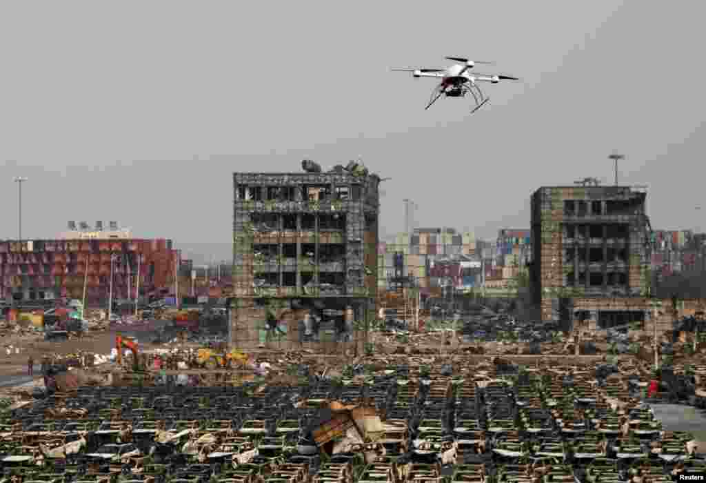 A drone operated by paramilitary police flies over the site of last week&#39;s explosions at Binhai new district in Tianjin, China.