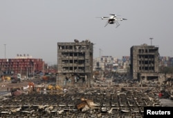 FILE - A drone operated by paramilitary police flies over the site of last week's explosions at Binhai new district in Tianjin, China, August 17, 2015.