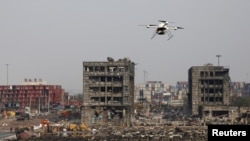 Diyaarad Drone ah oo dul mareysa goobta qaraxa uu ka dhacay ee Tianjin, China, August 17, 2015.