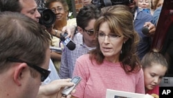 Former Alaska Governor Sarah Palin, holding a booklet depicting Paul Revere, speaks briefly with the media as she tours Boston's North End neighborhood, June 2, 2011 (file photo).