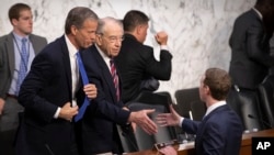 Senate Commerce, Science, and Transportation Committee Chairman John Thune, R-S.D., left, and Senate Judiciary Committee Chairman Chuck Grassley, R-Iowa, shake hands Facebook CEO Mark Zuckerberg on Capitol Hill in Washington, Tuesday, April 10, 2018. (AP