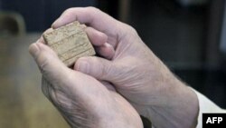 Профессор Чикагского университета Роберт Биггс держит глиняную табличку с текстом на аккадском языке. Чикаго. 28 мая 2011 года